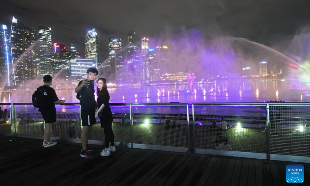 Tourists view the Spectra light and water show, returning after a 2-year hiatus due to the COVID-19 countermeasures, held at Singapore's Marina Bay Sands on April 28, 2022. Photo:Xinhua