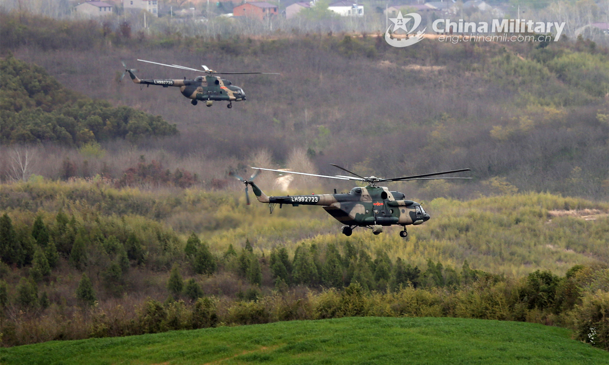 Two military helicopters attached to an army aviation brigade under the PLA 72nd Group Army fly at an ultralow altitude in the tactical penetration flight training on March 22, 2022. Photo: China Military