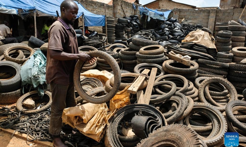 Eric Rugomoka looks through worn-out tires at a tire workshop in Makerere Kivulu of Kampala, Uganda, March 7, 2022.(Photo: Xinhua)