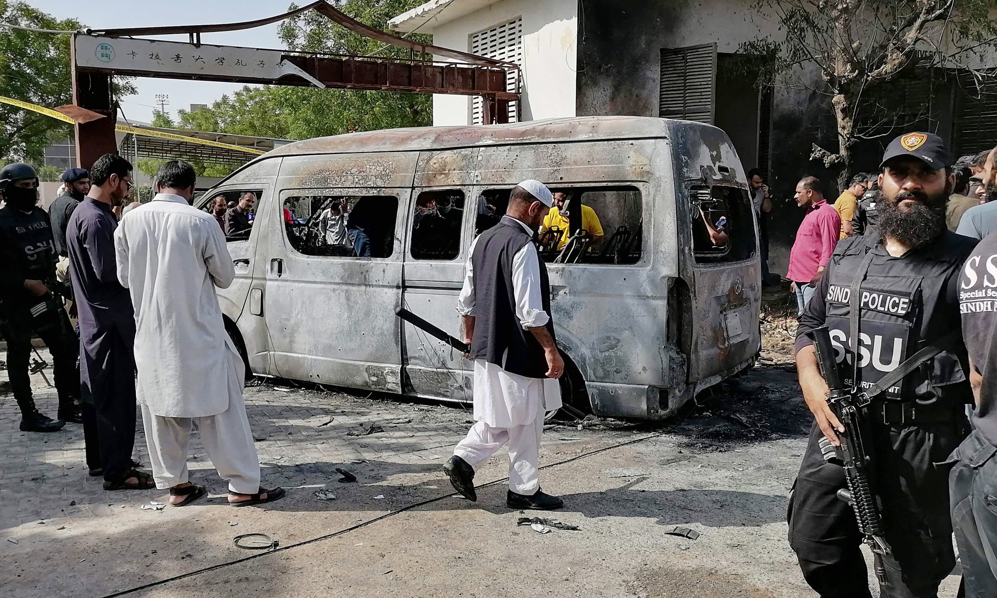 Police inspect a site around a damaged vehicle following a suicide bombing near the Confucius Institute affiliated with the Karachi University, in Karachi on April 26, 2022. A woman suicide bomber from a Pakistan separatist group killed four people, including three Chinese nationals, in an attack on a vehicle carrying staff from the Confucius Institute affiliated with the Karachi University. Photo: AFP