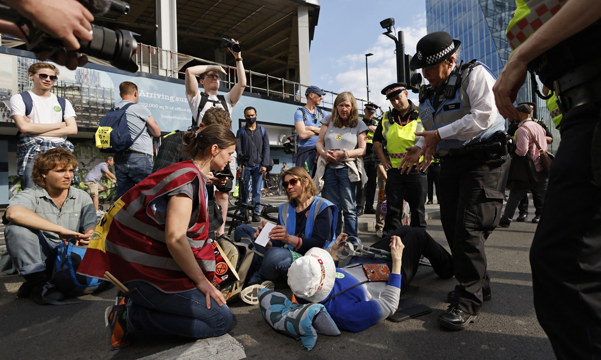 City of London police speak with activists from the climate change protest group Extinction Rebellion as they block Blackfriars Bridge in London on April 15, 2022. Photo: AFP