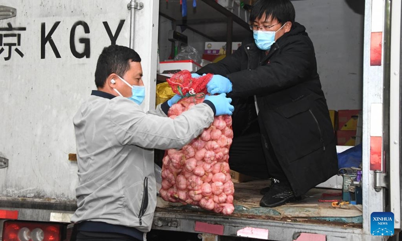 Staff members unload vegetables from a truck at a residential area in Haidian District, Beijing, capital of China, April 27, 2022. Communities in Haidian District have strengthened the supply of daily necessities for residents following a recent COVID-19 resurgence. (Xinhua/Ren Chao)
