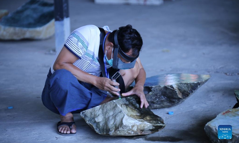 A merchant views a jade stone during the 57th Myanmar Gems Emporium in Nay Pyi Taw, Myanmar, April 27, 2022. The seven-day event will last until April 28.(Photo: Xinhua)