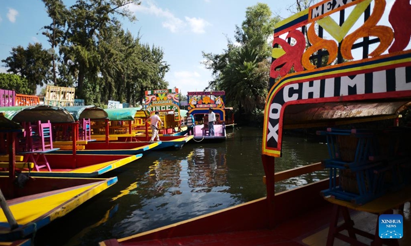 A boatman walks on the trajineras on the lake of Xochimilco, in Mexico City, capital of Mexico, April 27, 2022. Xochimilco was declared in 1987 as World Heritage Site by the UNESCO. A tour on colorful trajineras along its waterways is one of the popular activities for tourists.Photo:Xinhua