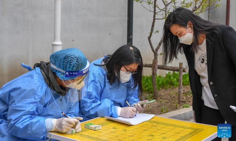 Staff members fill a pass card for a resident in Jilin City, northeast China's Jilin Province, April 28, 2022. Jilin City cleared all areas classified as high and medium-risk for COVID-19, local authorities said on Thursday.Photo:Xinhua