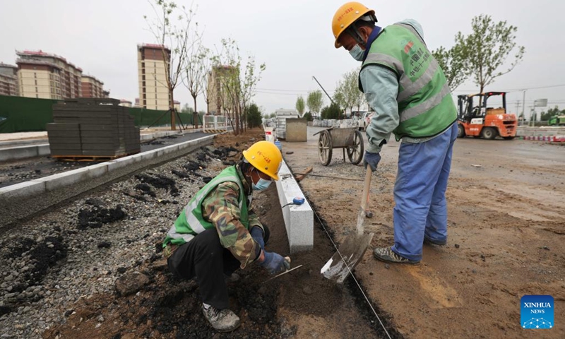 Workers work at the construction site of Aowei street in Xiong'an New Area, north China's Hebei Province, April 28, 2022. Aowei street is a main street going from the east to the west in Xiong'an New Area. The project will be completed soon.Photo:Xinhua