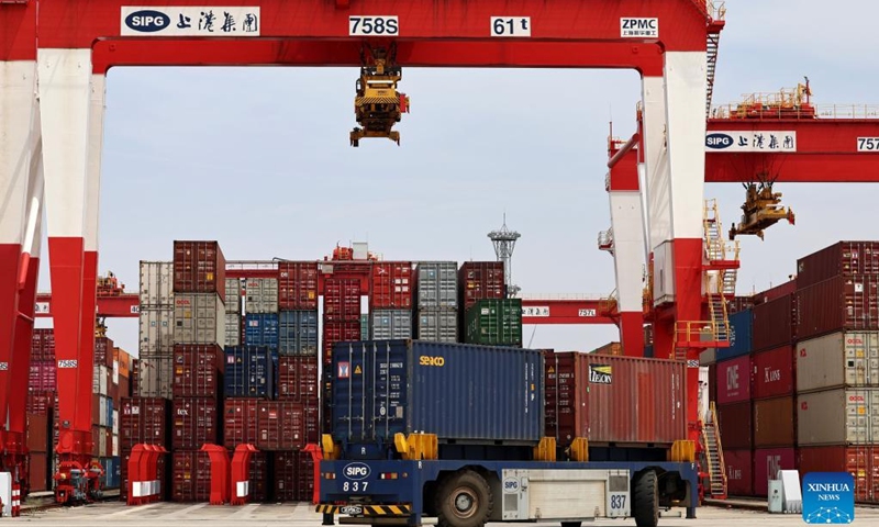 A truck carrying containers is seen at the container dock of Shanghai's Yangshan Port in east China, April 27, 2022. About 25,000 staff members stick to their posts in Shanghai port to guarantee water transportation and improve logistics efficiency amid challenges caused by the recent resurgence of COVID-19 in Shanghai.(Photo: Xinhua)
