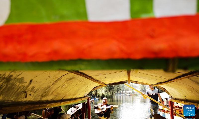 A musician plays music for tourists on the lake of Xochimilco, in Mexico City, capital of Mexico, April 27, 2022. Xochimilco was declared in 1987 as World Heritage Site by the UNESCO. A tour on colorful trajineras along its waterways is one of the popular activities for tourists.Photo:Xinhua