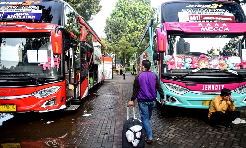 A passenger brings luggage before boarding a free-of-charge bus to his hometown in Jakarta, Indonesia. April 26, 2022.(Photo: Xinhua)