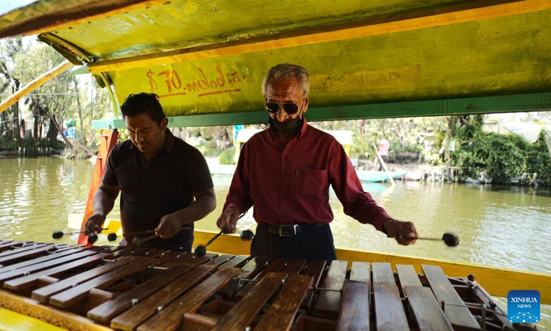 Musicians play music for tourists riding a trajinera on the lake of Xochimilco, in Mexico City, capital of Mexico, April 27, 2022. Xochimilco was declared in 1987 as World Heritage Site by the UNESCO. A tour on colorful trajineras along its waterways is one of the popular activities for tourists.Photo:Xinhua
