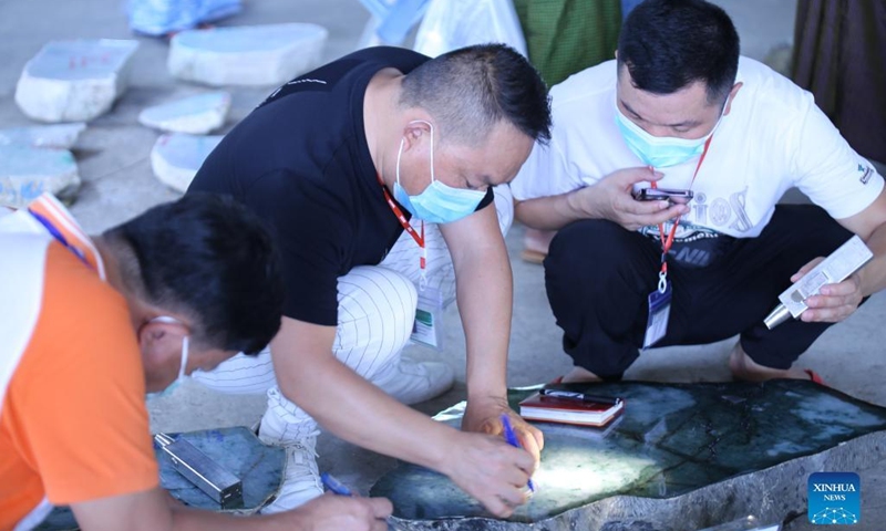 Merchants examine jade stones during the 57th Myanmar Gems Emporium in Nay Pyi Taw, Myanmar, April 27, 2022. The seven-day event will last until April 28.(Photo: Xinhua)