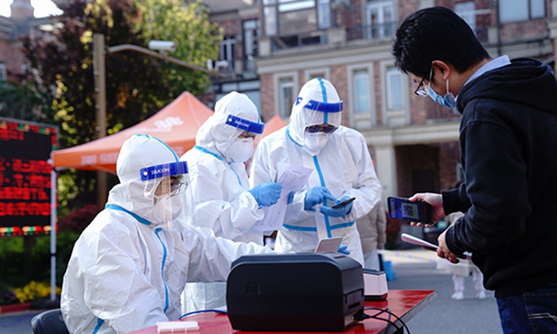 Volunteers help a resident register for nucleic acid test at a community in Songjiang district of Shanghai, East China, April 4, 2022. Photo: Xinhua