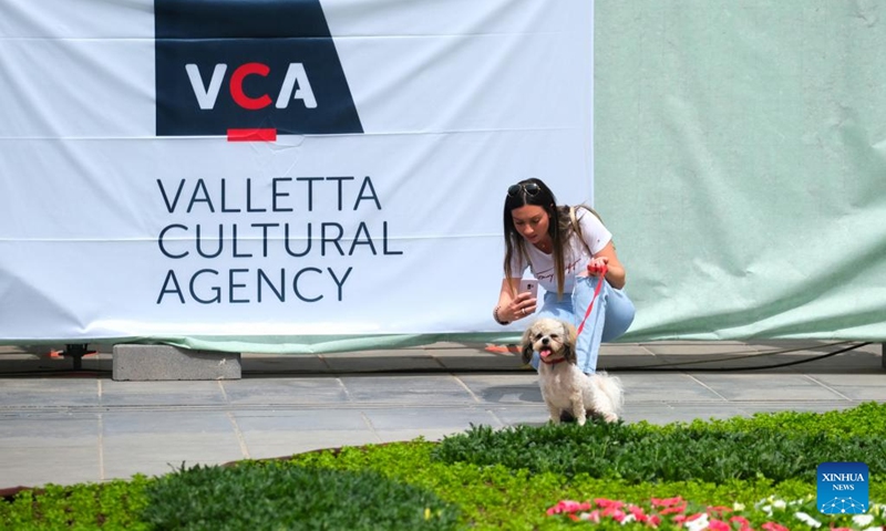 A woman takes photos in St. George's Square with flowering display in Valletta, capital of Malta, on April 30, 2022. The ninth edition of the Valletta Green Festival takes place between April 28 and May 1 with this year's theme natural habitats. (Photo by Jonathan Borg/Xinhua)