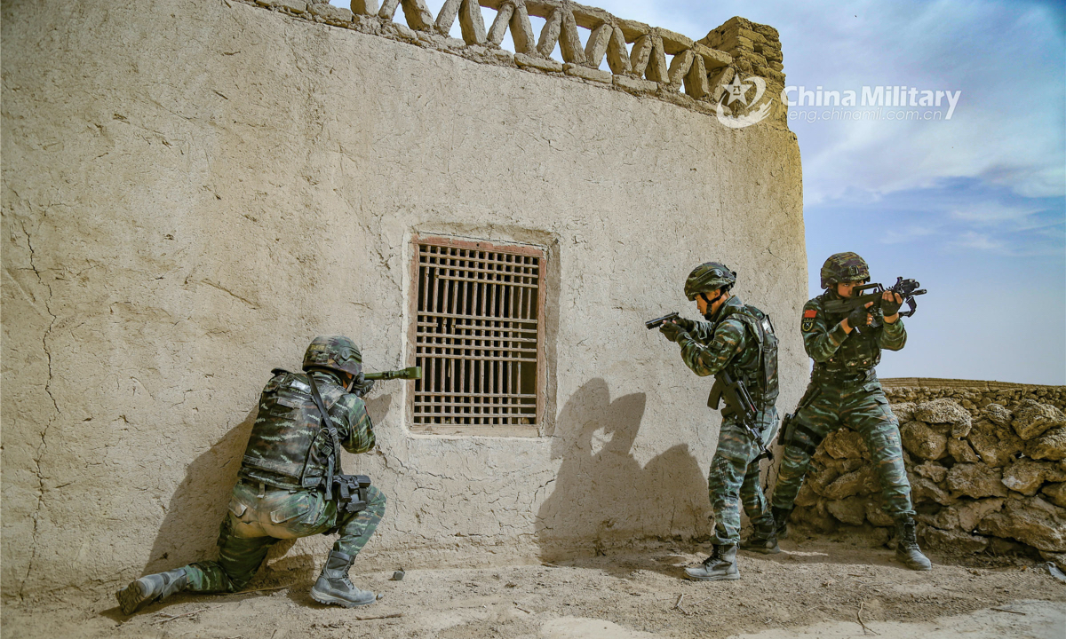 A special operations soldier assigned to the Turban detachment under the Chinese People's Armed Police (PAP) Xinjiang Corps peeps into a suspicious house with reconnaissance device, while his teammates provide security during a capture and annihilation combat training exercise on April 13, 2022. (eng.chinamil.com.cn/Photo by Wang Xiaojie)
