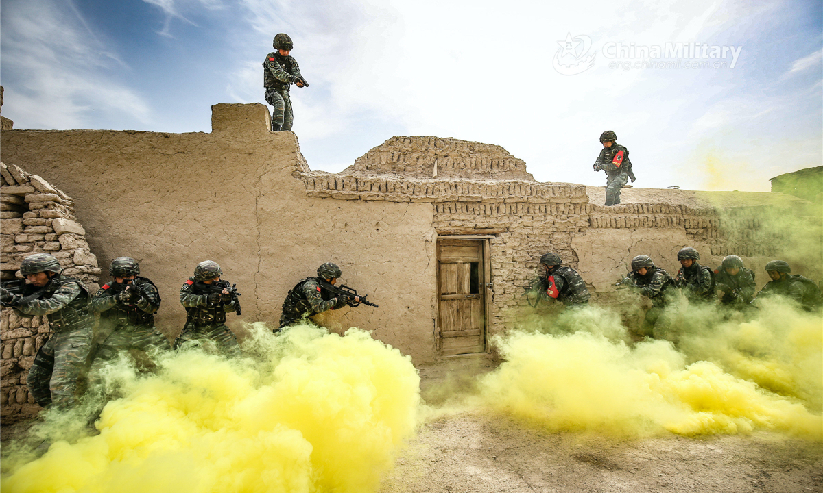 In mid-April, the Turban detachment under the Chinese People's Armed Police (PAP) Xinjiang Corps staged capture and annihilation combat training exercises to enhance the special operations soldiers' combat capability. The picture taken on April 13, 2022 shows the assault team members taking advantageous position with the help of smoke bomb and preparing to break into a suspicious house during the training exercise. (eng.chinamil.com.cn/Photo by Wang Xiaojie)
