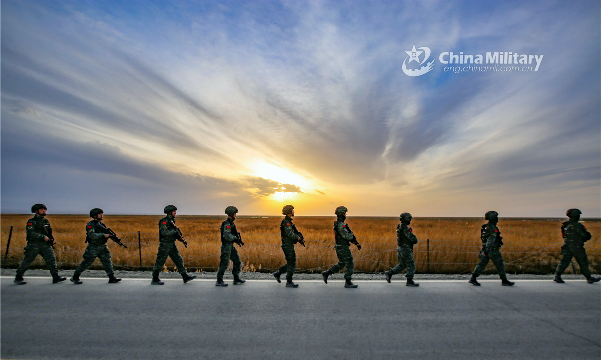The special operations soldiers assigned to the Turban detachment under the Chinese People's Armed Police (PAP) Xinjiang Corps march past the Aiding Lake Wetland in the sunset glow after a capture and annihilation combat training exercise on April 11, 2022.(eng.chinamil.com.cn/Photo by Wang Xiaojie)
