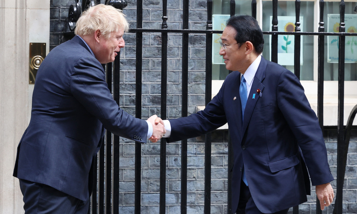 Japanese Prime Minister Fumio Kishida (R) and British Prime Minister Boris Johnson shake hands prior to their meeting at 10 Dowing Street Office in London on May 5, 2022. Photo: AFP