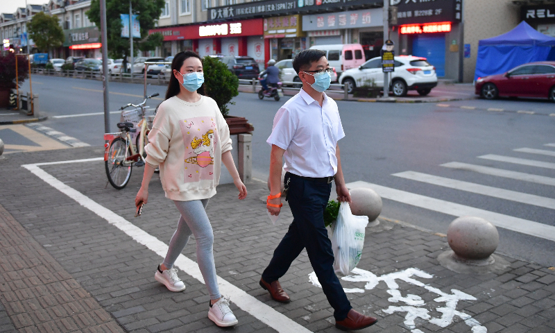 Residents walk outside their compound in Fengjing township, Jinshan district, Shanghai. Photo: VCG
