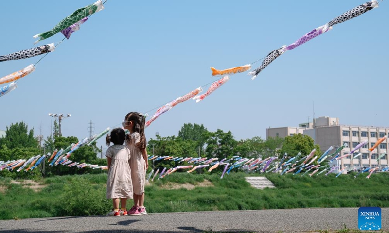 Children view carp streamers, known as koinobori, at the Fudobashi of Koshigaya City, Saitama Prefecture in Japan, May 5, 2022. Japan marks its Children's day on May 5, on which families raise the koinobori to pray for happiness for children. (Xinhua)
