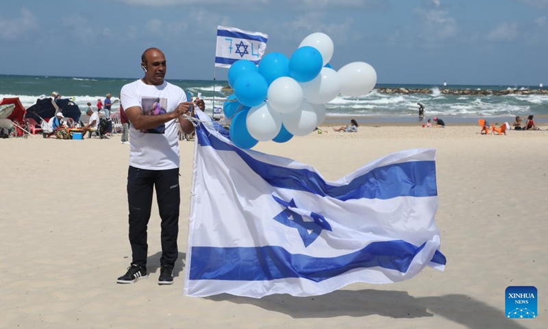 People wait for an air show celebrating Israel's 74th Independence Day on a beach in Tel Aviv, Israel, on May 5, 2022. Israelis joined a slew of national celebrations to mark the country's 74th Independence Day. This year's Independent Day began on Wednesday evening and will last till Thursday evening.(Photo: Xinhua)