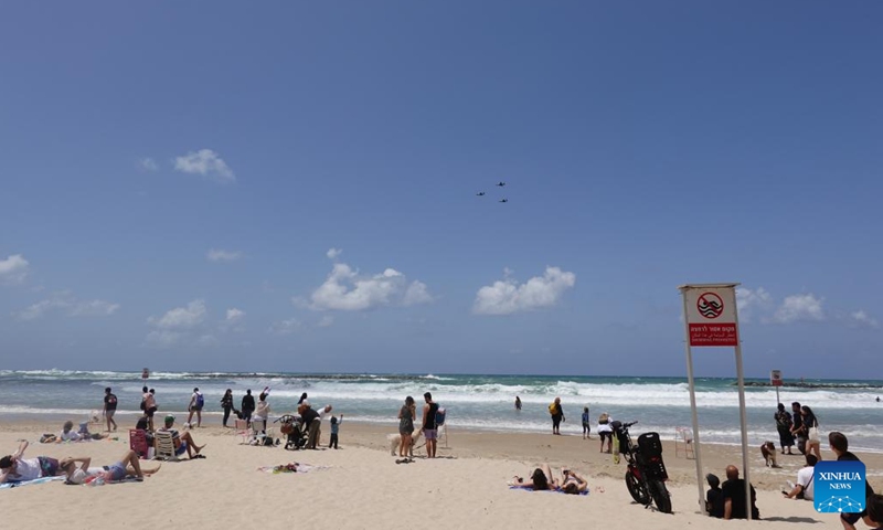 People watch an air show celebrating Israel's 74th Independence Day on a beach in Tel Aviv, Israel, on May 5, 2022. Israelis joined a slew of national celebrations to mark the country's 74th Independence Day. This year's Independent Day began on Wednesday evening and will last till Thursday evening.(Photo: Xinhua)