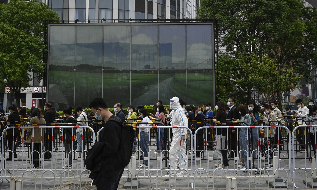People wait in line to be tested for COVID-19 at a swab collection site in Beijing on April 25, 2022. Photo: AFP
