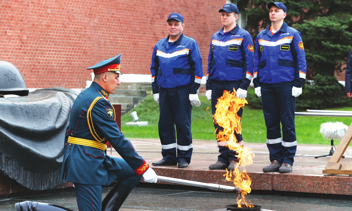 a russian honor guard member and mosgaz workers