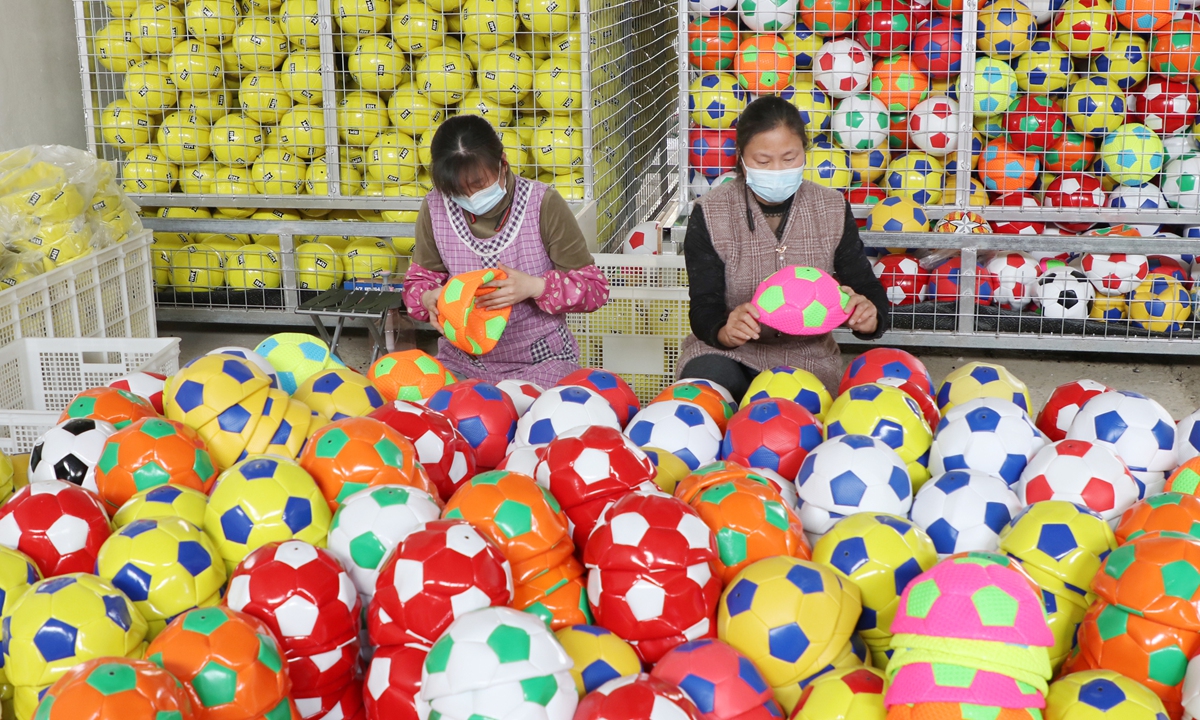 Workers in Lianyungang, East China's Jiangsu Province make ball products on May 8, 2022. China's General Administration of Sport plans to enhance the country's sports industry, vowing to launch or rebuild over 1,000 sports venues during the 14th Five-Year Plan period (2021-25).
Photo: cnsphoto