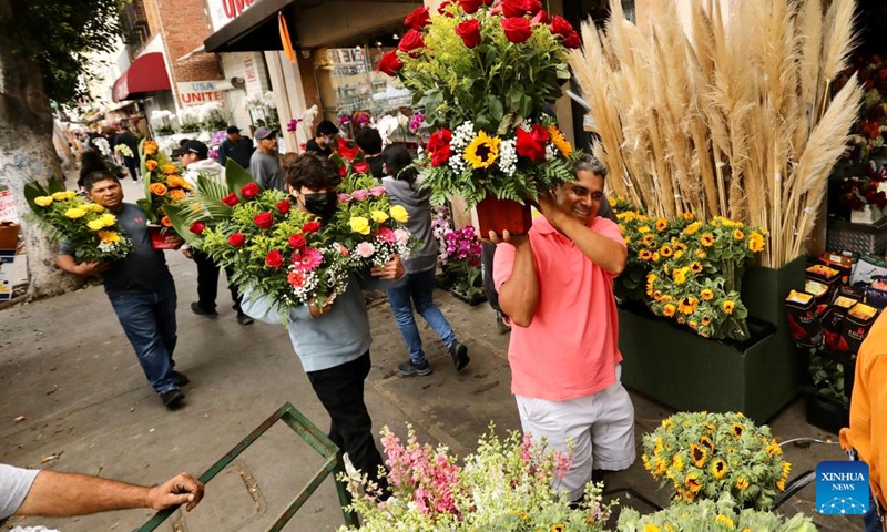 People carrying flowers are seen at a flower market on Mother's Day in downtown Los Angeles, the United States, on May 8, 2022.Photo:Xinhua