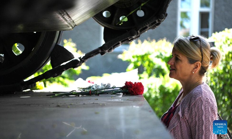A woman presents flowers near a tank to commemorate the 77th anniversary of the end of World War II in Europe, known as Victory in Europe Day, at German-Russian Museum in Berlin, capital of Germany, on May 8, 2022.Photo:Xinhua