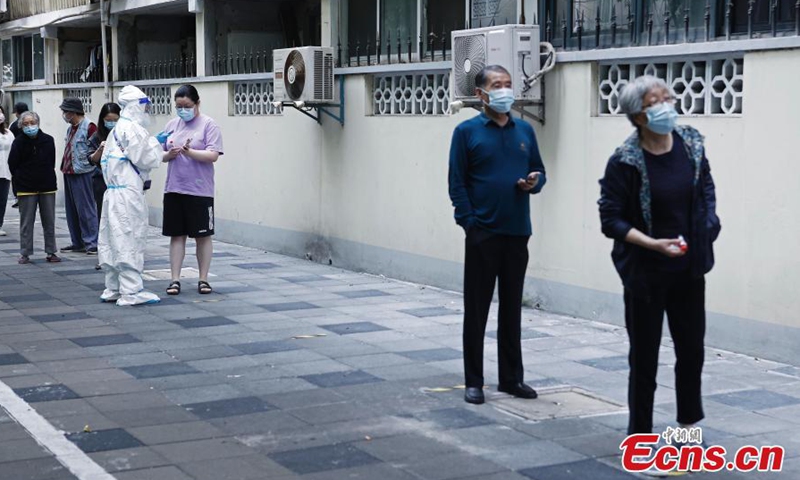 2022年5月11日，工作人员在中国东部上海的一个临时检测点为居民登记信息。（照片：中新社/尹立勤）