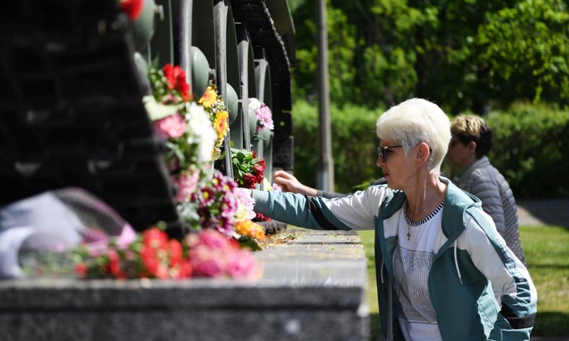 A woman presents flowers near a tank to commemorate the 77th anniversary of the end of World War II in Europe, known as Victory in Europe Day, at German-Russian Museum in Berlin, capital of Germany, on May 8, 2022.Photo:Xinhua