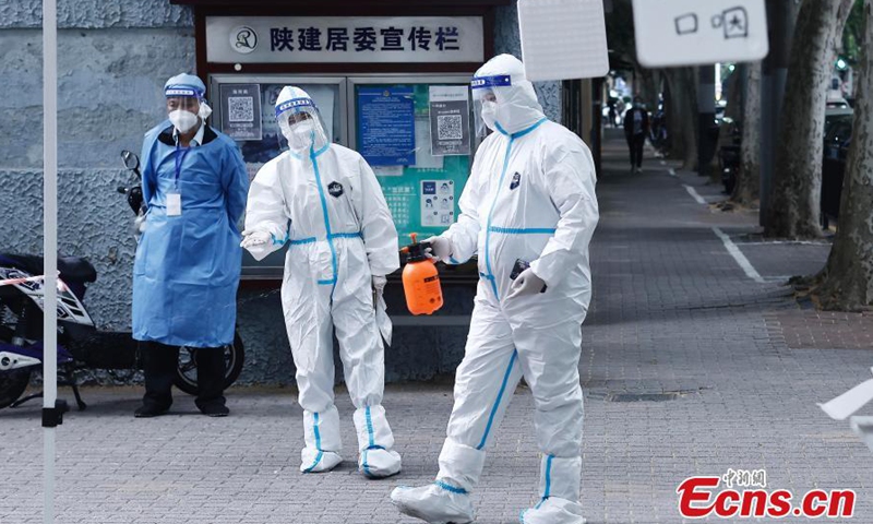 Staff members disinfect at a temporary testing site in east China's Shanghai, May 11, 2022. (Photo: China News Service/Yin Liqin)
