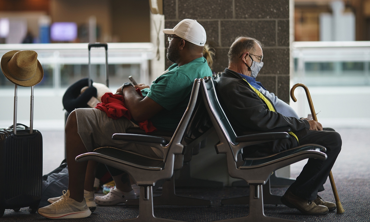 Travelers sit in a waiting area at Rhode Island T.F. Green International Airport on April 19, 2022, after a federal judge's decision to strike down a national mask mandate. Photo: VCG