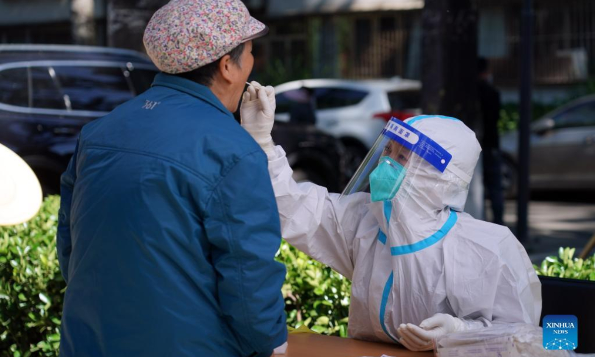A medic takes a swab sample from a resident for nucleic acid test at a community in Haidian District of Beijing, capital of China, May 13, 2022. Beijing has started three additional rounds of mass nucleic acid testing in 12 districts from Friday to Sunday, as the Chinese capital races against time to contain the latest resurgence of COVID-19 infections. Photo:Xinhua
