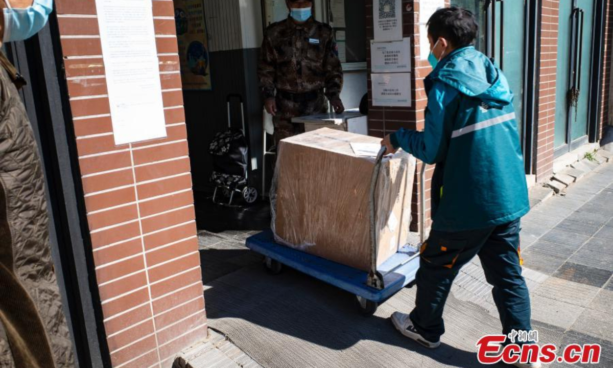 A delivery man carries a package to a community in Chaoyang district, Beijing, May 13, 2022. Photo:China News Service