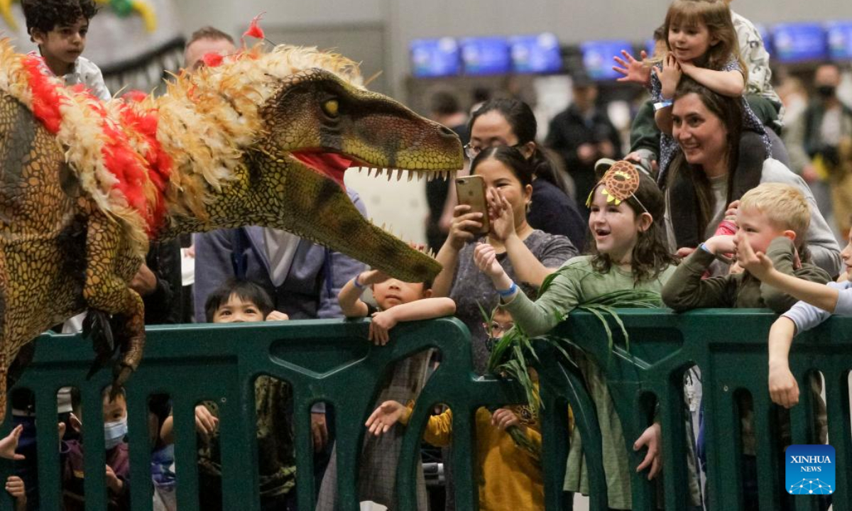 People watch a raptor show at the Jurassic Quest exhibition at Vancouver Convention Centre in Vancouver, British Columbia, Canada, on May 13, 2022. Photo:Xinhua