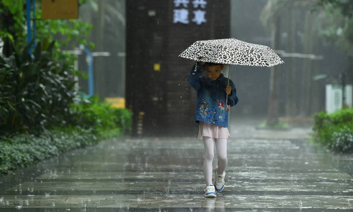 A girl walks on the street of South China's Guangzhou on May 11, 2022. The rainfall gradually increased in the evening. Photo: VCG