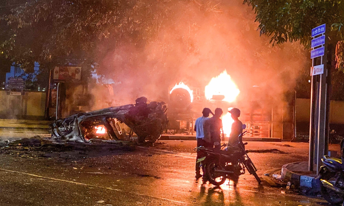 A vehicle belonging to the security personnel and a bus set alight is pictured near Sri Lanka's outgoing Prime Minister Mahinda Rajapaksa's official residence in Colombo, Sri Lanka on May 9, 2022. Photo: VCG