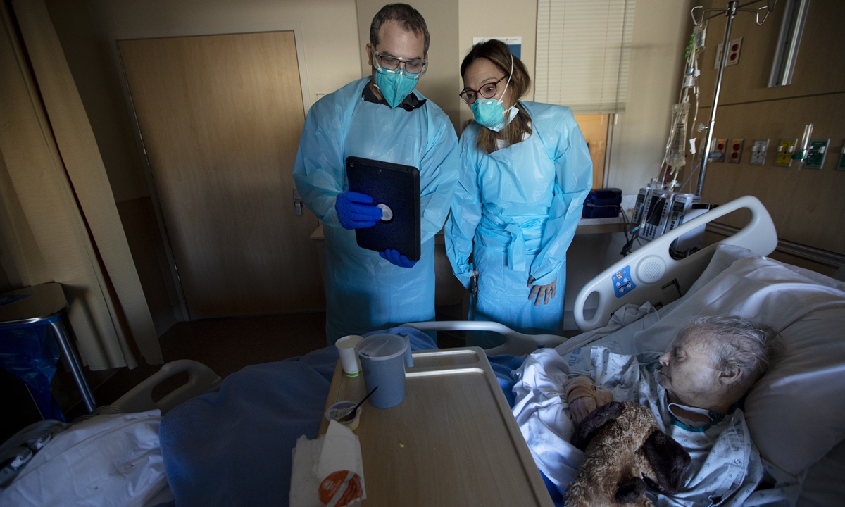 A doctor and a clergyman check an aged COVID-19 patient in California on December 3, 2020. Photo: VCG