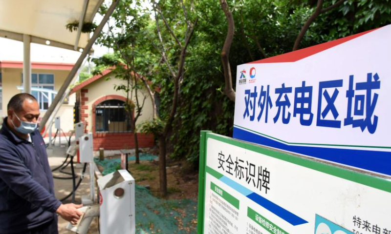 A driver is to charge his electric car at a shared electric bus charging station in Qingdao, east China's Shandong Province, May 11, 2022. Qingdao City has recently opened some electric bus charging stations to the public. Private vehicles and ride-hailing cars can share the charging facilities together with the public buses. (Xinhua/Li Ziheng)