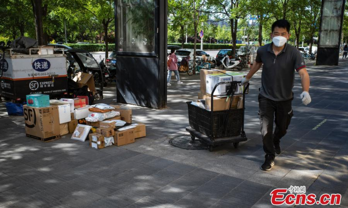 A man delivers packages to a community in Chaoyang District, Beijing, May 13, 2022. Photo:China News Service
