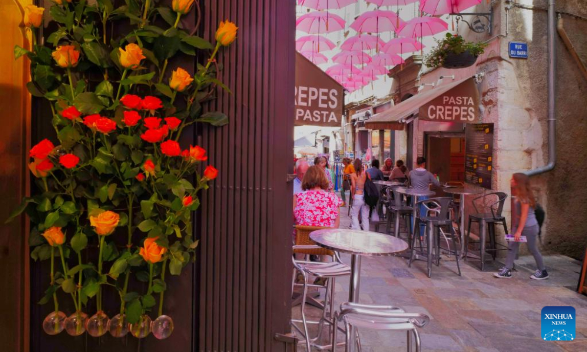 Roses and pink umbrellas are seen during the 50th ExpoRose in Grasse, southern France, on May 13, 2022. The city center of Grasse was turned into rose gardens during the three-day ExpoRose festival which kicked off here on Friday. Photo:Xinhua