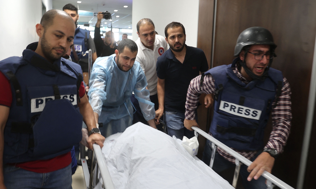 Journalists escort the body of veteran Al Jazeera journalist Shireen Abu Akleh, who was shot dead by Israeli troops as she covered a raid on the West Bank's Jenin refugee camp on May 11, 2022, at the hospital in Jenin. Al Jazeera's Nida Ibrahim said Abu Akleh was a 