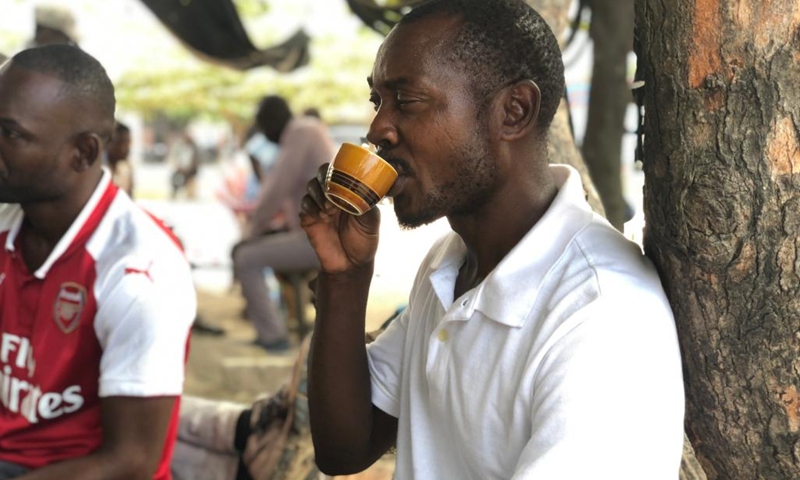 A Tanzanian sips coffee at a street coffee stall in Dar es Salaam, Tanzania, in May 9, 2022. Walking in the streets in Tanzania's commercial capital Dar es Salaam's suburbs, one is likely to see people seated under shades of trees drinking coffee at selected locations.(Photo: Xinhua)