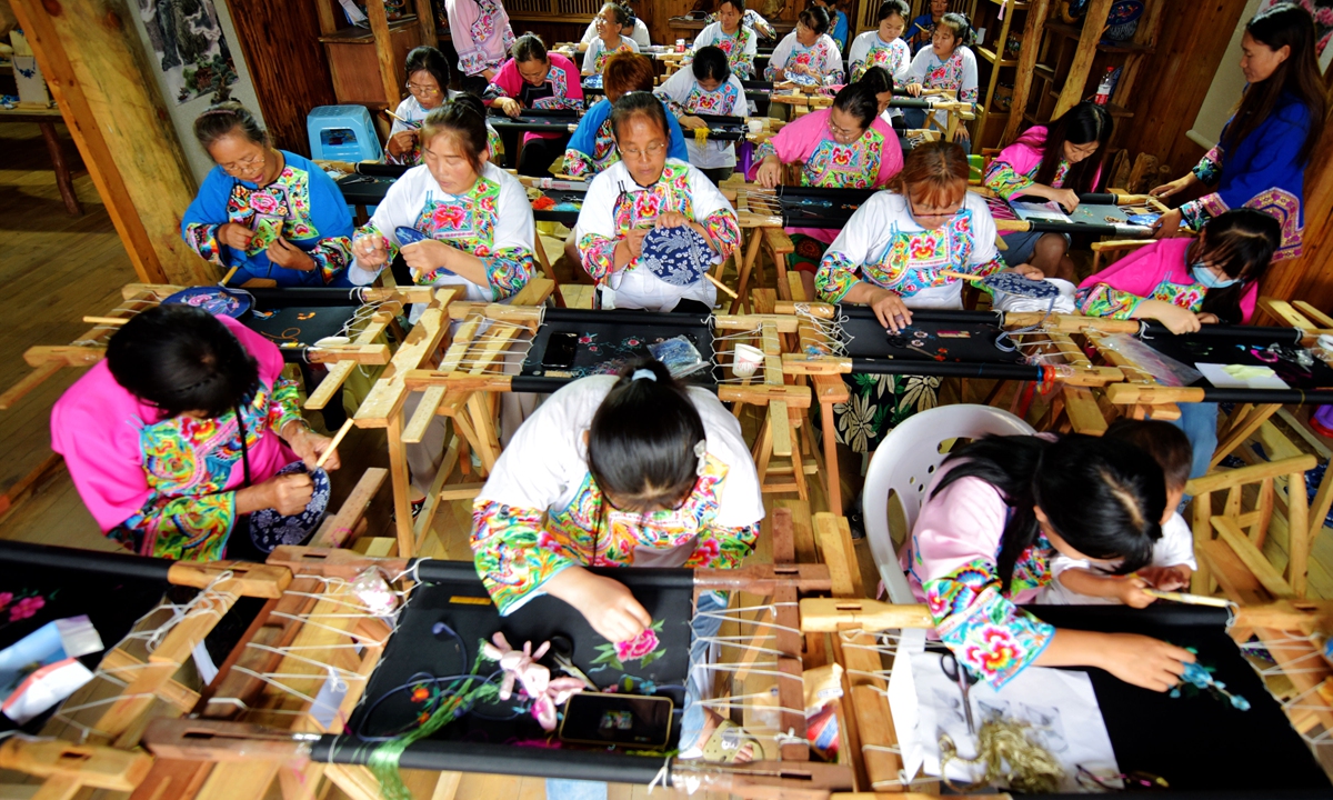Miao people work on embroidery in Chongqing. Photos: VCG