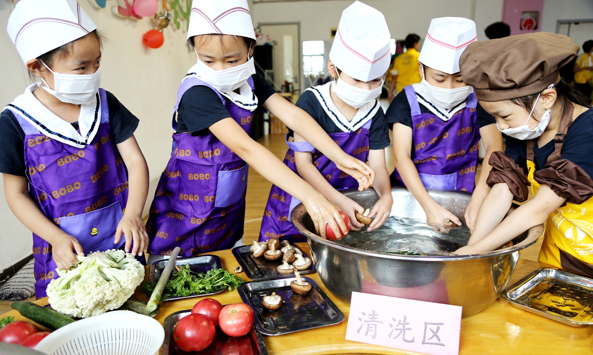 Kids from a kindergarten in East China's Jiangsu Province wash vegetables to prepare for a cooking class on August 15, 2019.Photo: VCG