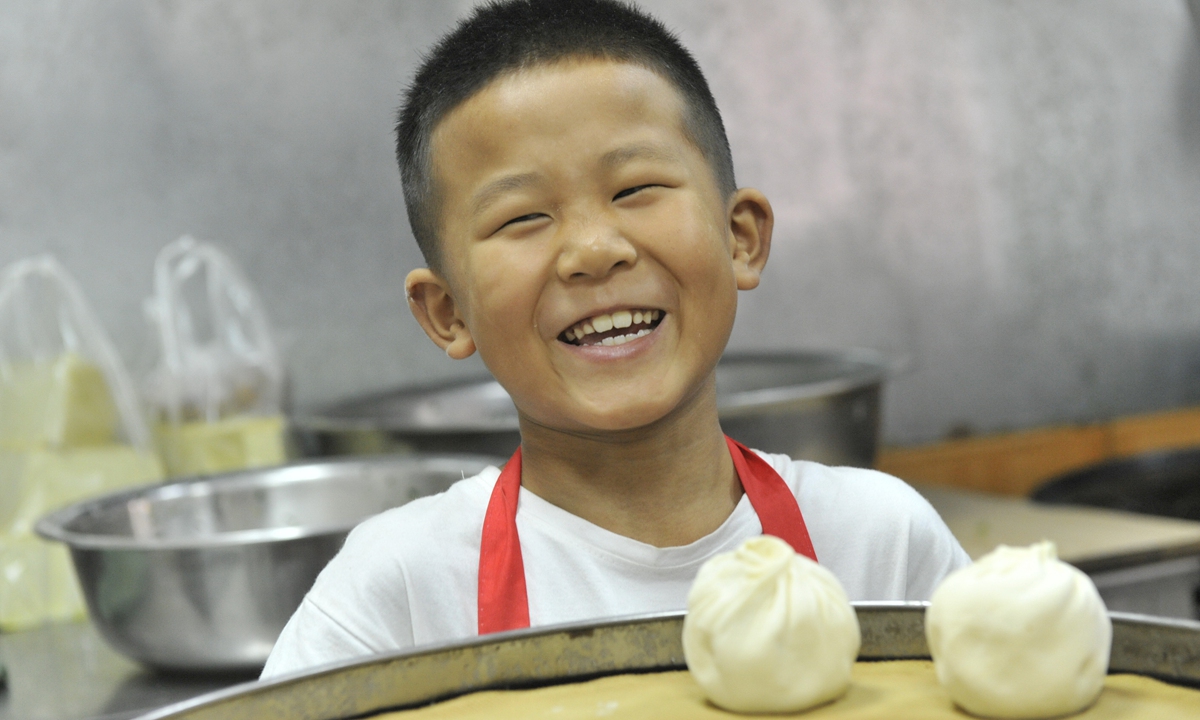 A seven-year-old boy from Northwest China's Shaanxi Province learns to make Baozi, a type of yeast-leavened stuffed bun in various Chinese cuisines, on August 22, 2019.Photo: VCG