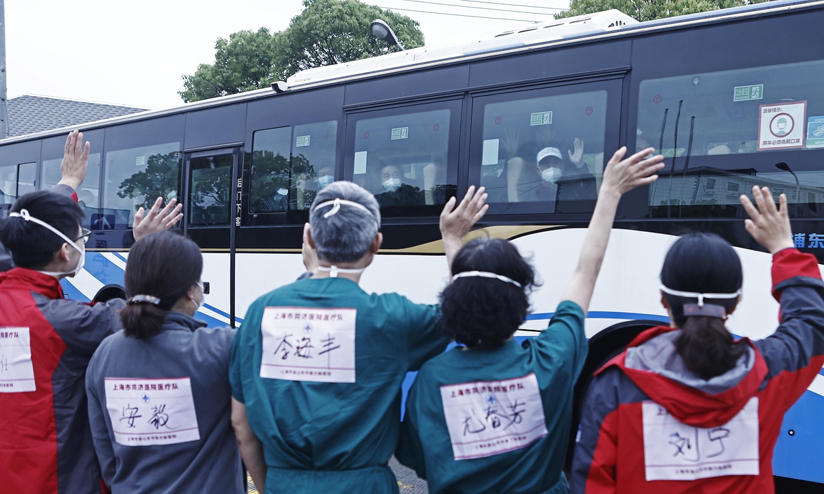 Members of a medical team wave to discharged patients at Tongji Hospital in Shanghai, May 13, 2022.  The last batch of 172 patients discharged from a makeshift hospital in Jinshan District of Shanghai recovered that day. Photo: cnsphoto
