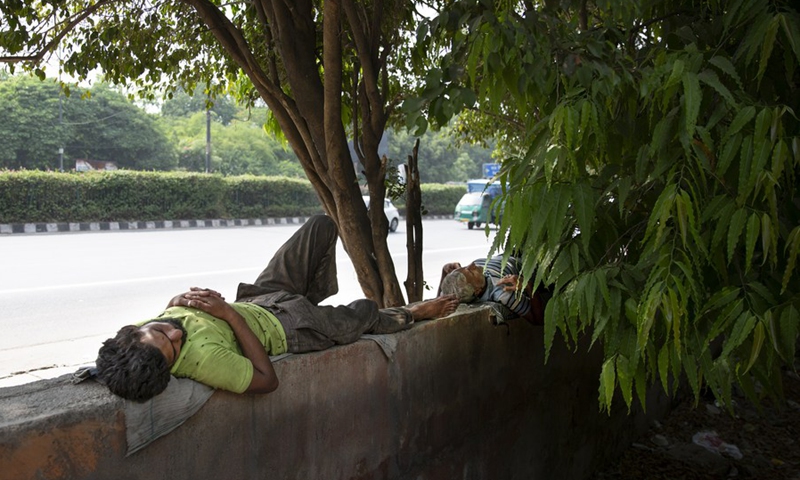 People take naps under shades of trees to get respite from the hot summer day in New Delhi, May 12, 2022.(Photo: Xinhua)